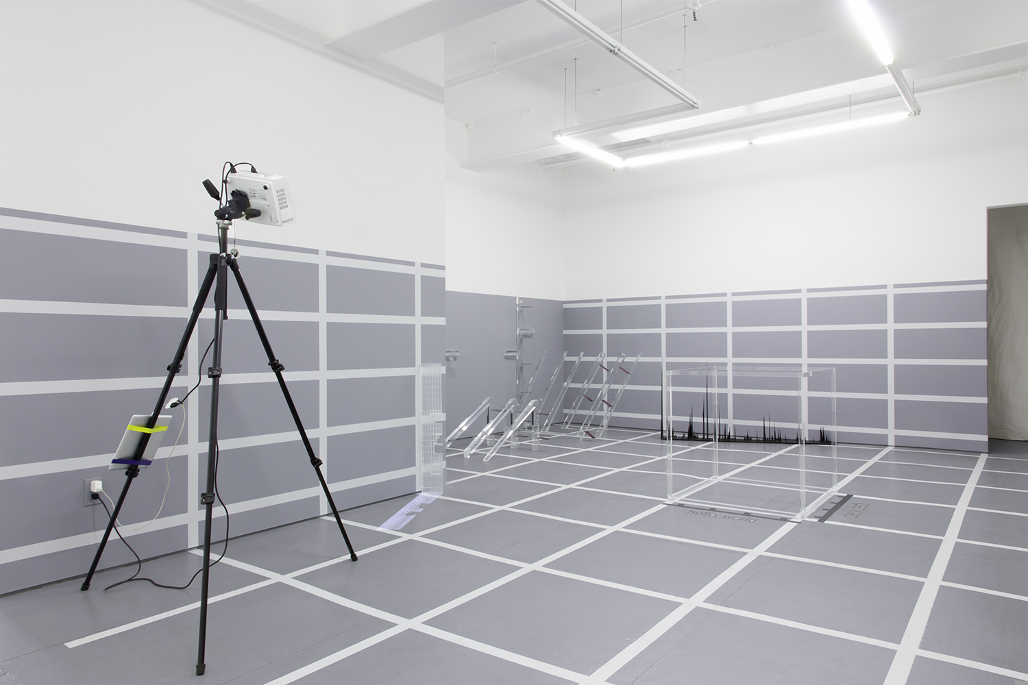 Installation view of 4 sculptural objects in a grid-lined exhibition space