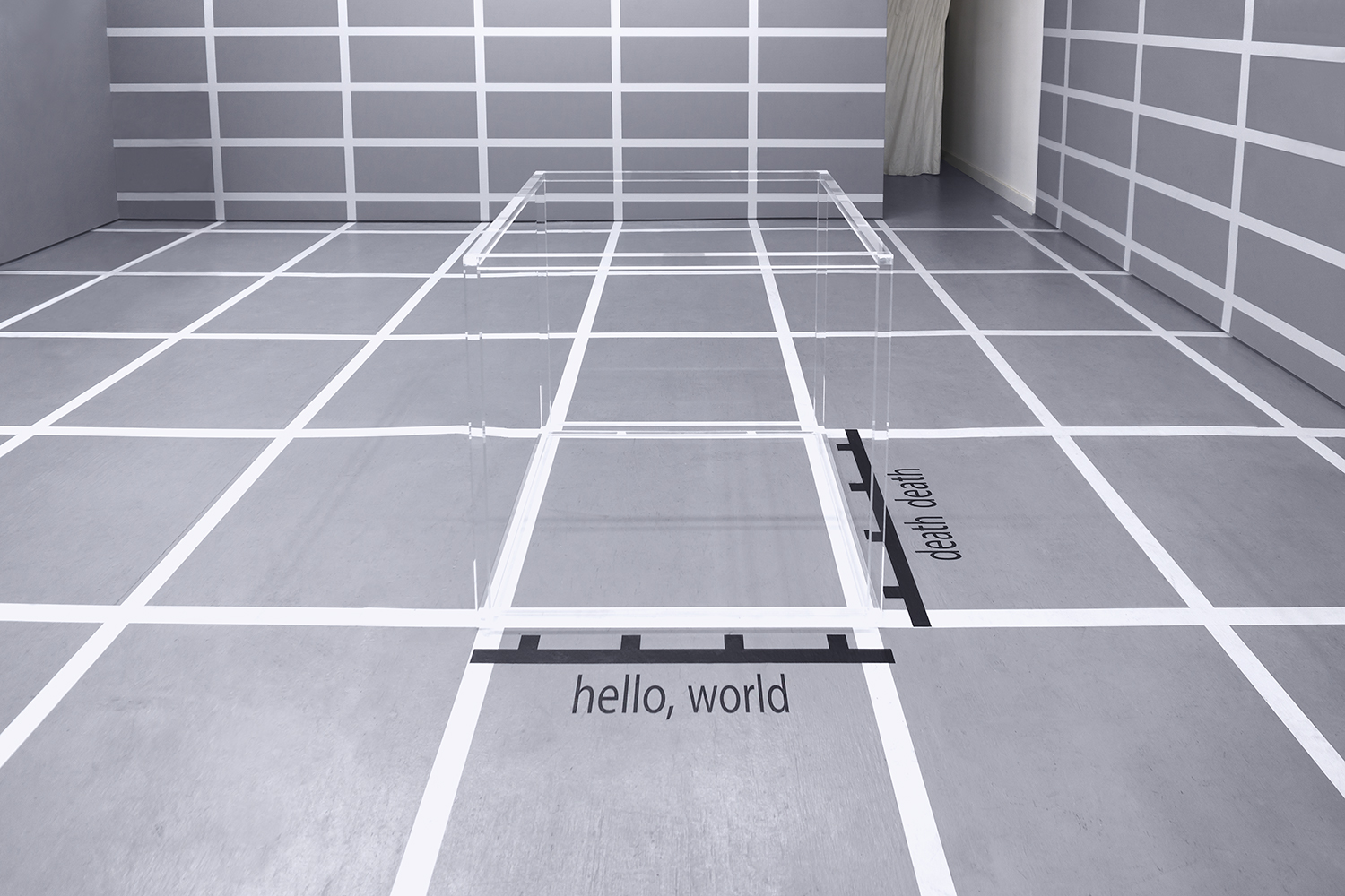 Wireframe acrylic cube and vinyl text on floor at bottom and right reading "hello world" and "death death"