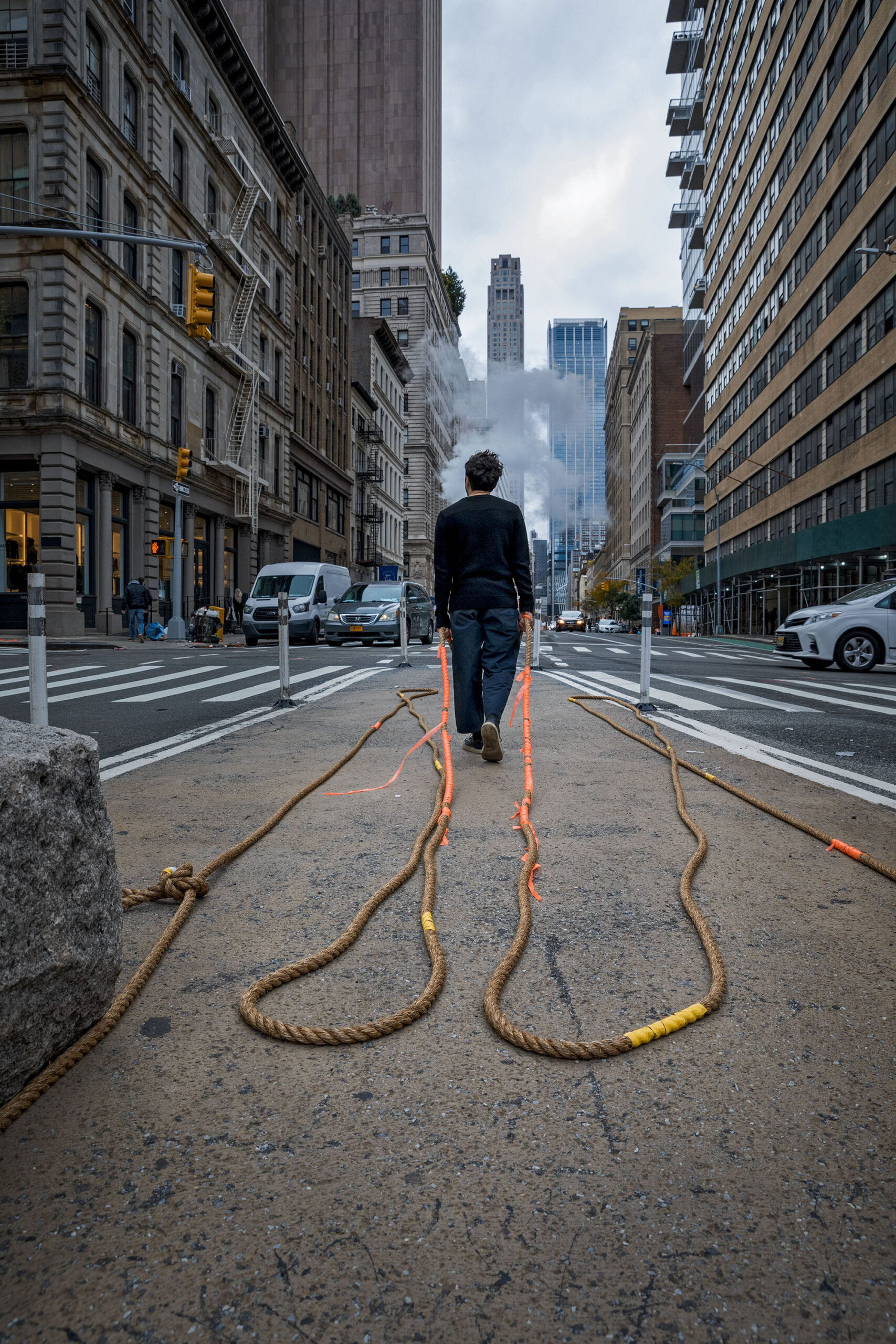 Performer walking slowly with rope into triangle to begin the work